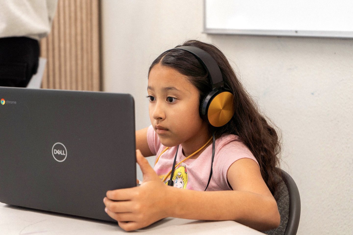A Hope Horizon student wearing headphones and working at a laptop in a classroom