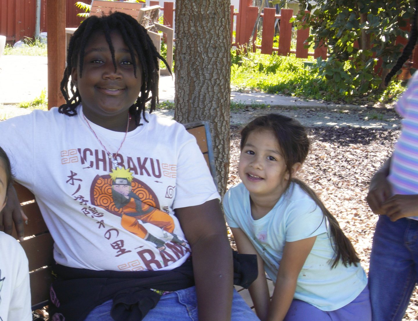 An older Hope Horizon student sitting outdoors with a younger student