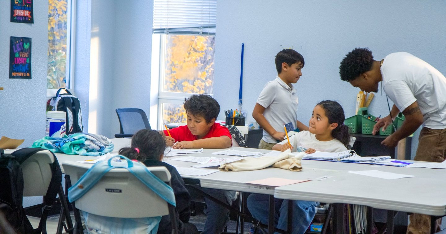 A Hope Horizon tutor helping students at a table